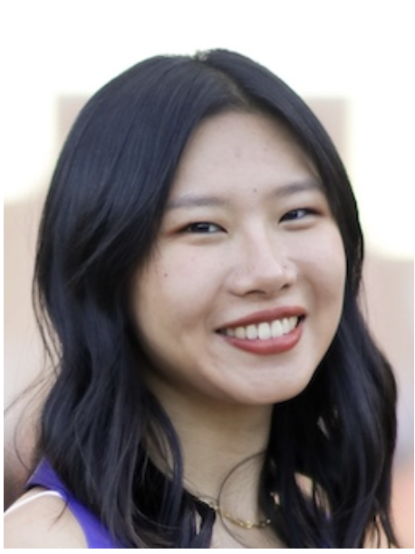 A lady with short black hair in a purple top smiling.