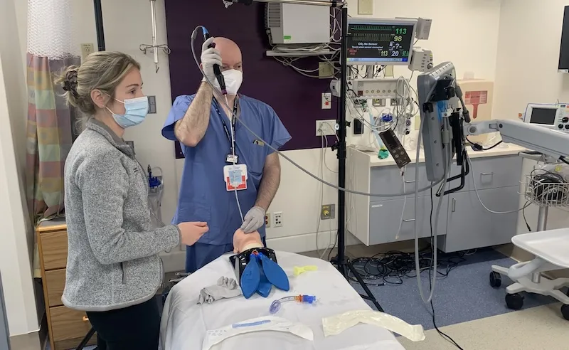 A man and woman practicing a lung procedure