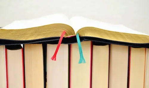 Open book sitting on top of a row of books