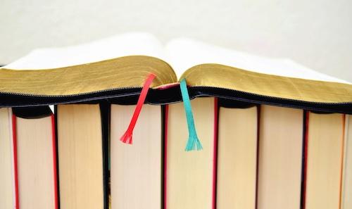 Open book sitting on top of a row of books