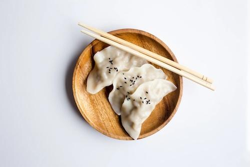 Plate of three dumplings with chopsticks 