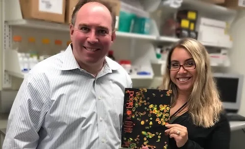 Dr. Italiano and Dr. Machlus in a lab holding a book