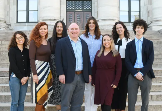 Two men and six women standing on stairs outside