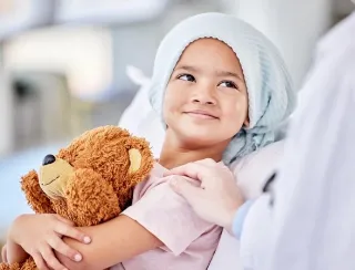 Child holding a teddy bear during a healthcare visit.