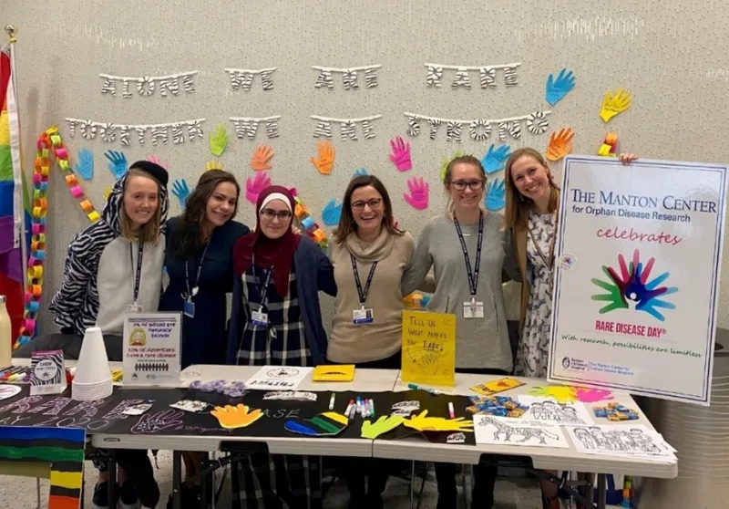 A group of woman gather behind a table for a group photo. 