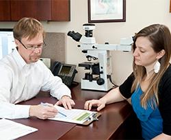 A man and woman sit across from each other at a desk. 