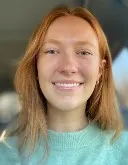 Headshot of Mary Corcoran, a woman with red hair who is a lab member of the nerd lab.