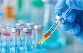 gloved hand using needle to insert liquid into test tubes