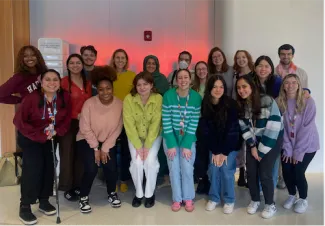 Three men and fifteen women in rainbow colored shirts