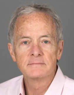 An older man with short grey hair, David Williams, gives the camera a close-lipped smile for his headshot photo.