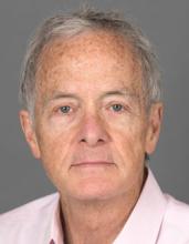 An older man with short grey hair, David Williams, gives the camera a close-lipped smile for his headshot photo.