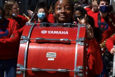 Child in band marches with large Yamaha drum