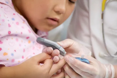 Doctor testing little girls blood insulin