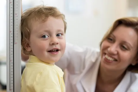 Young boy having his height measured by a doctor